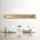 a minimalist living room setting with a large, long, horizontal painting hanging on the wall above two white bean bag chairs and a small black table.