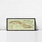 A framed vintage map of Cuba is displayed against a white wall.
