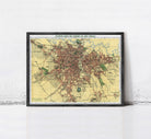 The image is a framed map of a city, likely from the early 20th century, depicting a detailed layout of the city's streets, landmarks, and other features.
