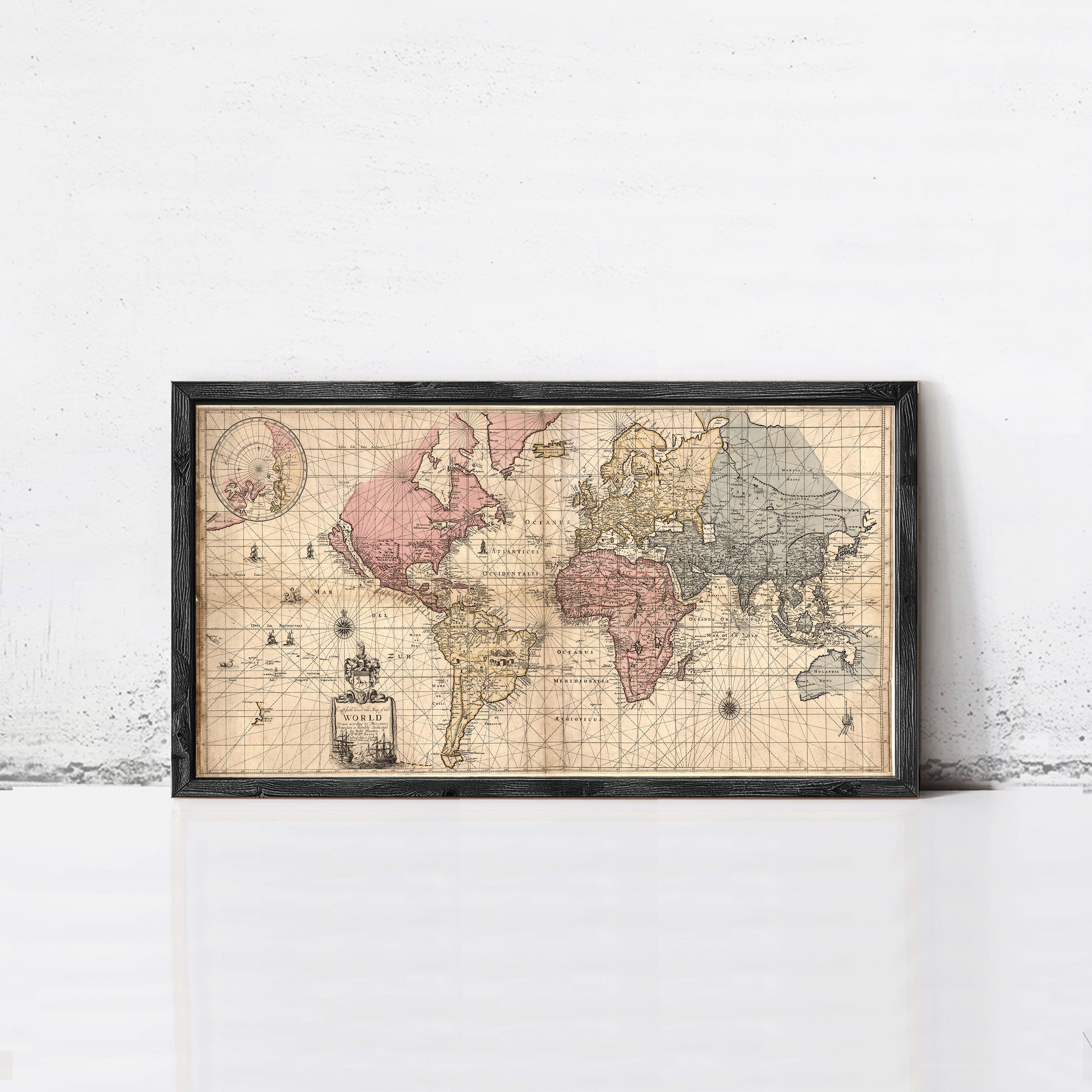 A framed vintage map of the world, depicting the continents and oceans in a detailed and intricate manner.