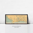 A framed map of Singapore, with a black border and yellow and green color scheme, displayed against a white wall.