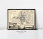 The image is a framed vintage map of a city, likely from the past, with various landmarks and streets depicted.