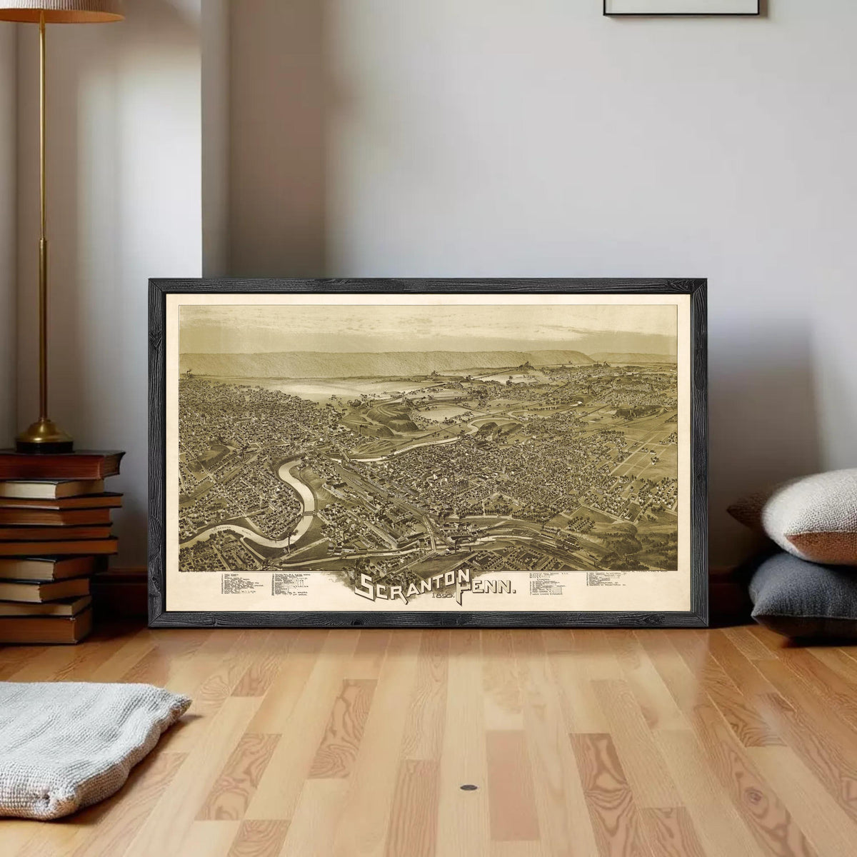 a framed map of Scranton, Pennsylvania, with a wooden floor and a stack of books in the background.