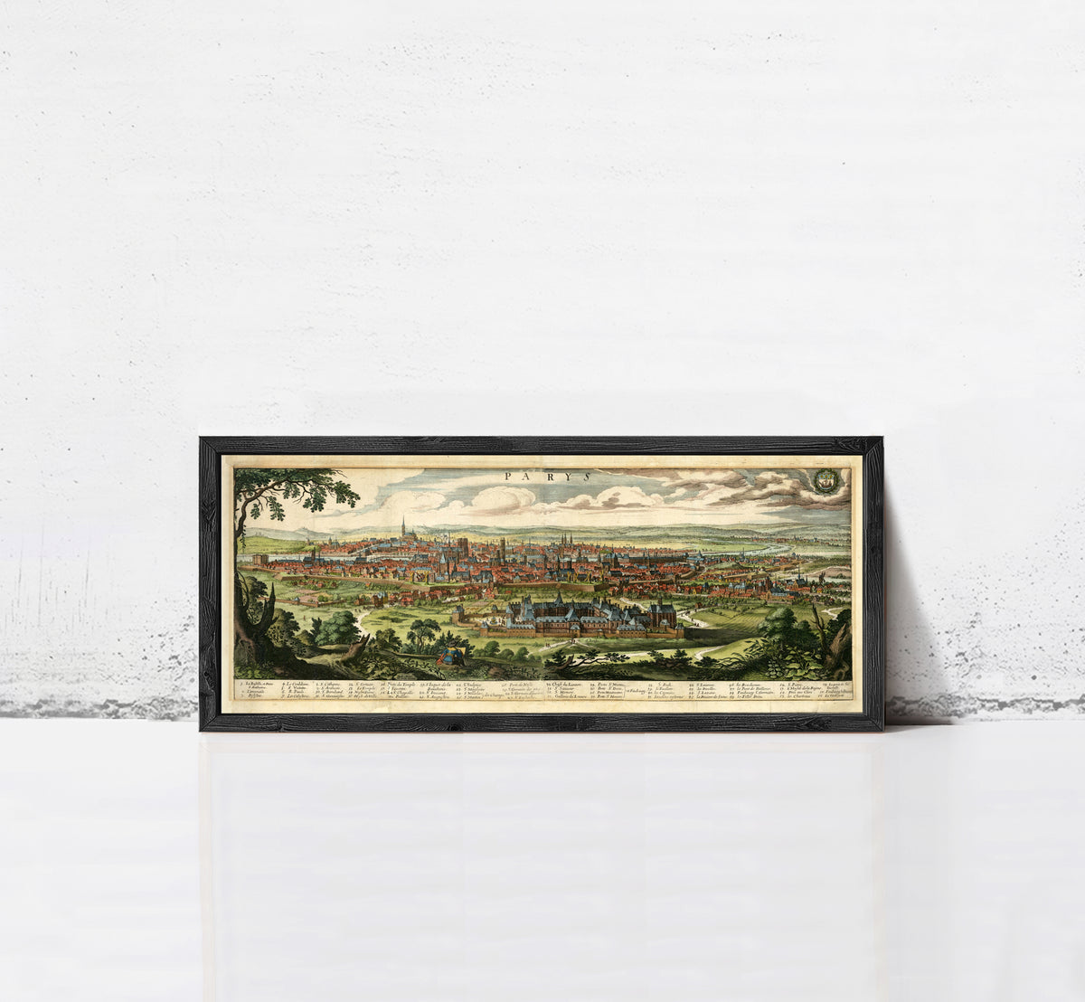 A framed illustration of a cityscape depicting a large, densely populated urban area with a mix of buildings, roads, and natural elements such as trees and grass.