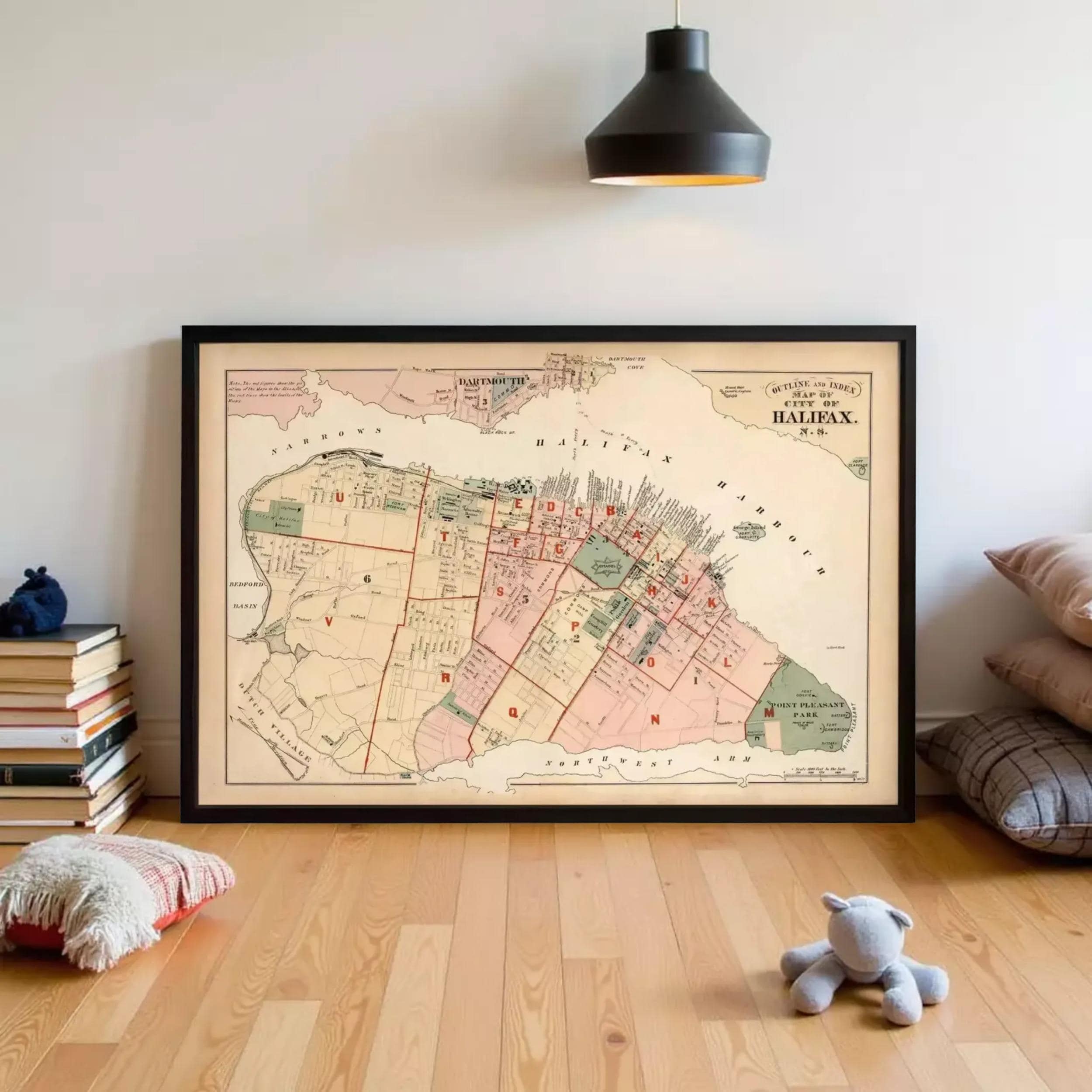 a framed map of the city of Montreal, Canada, with a black light fixture hanging above it.