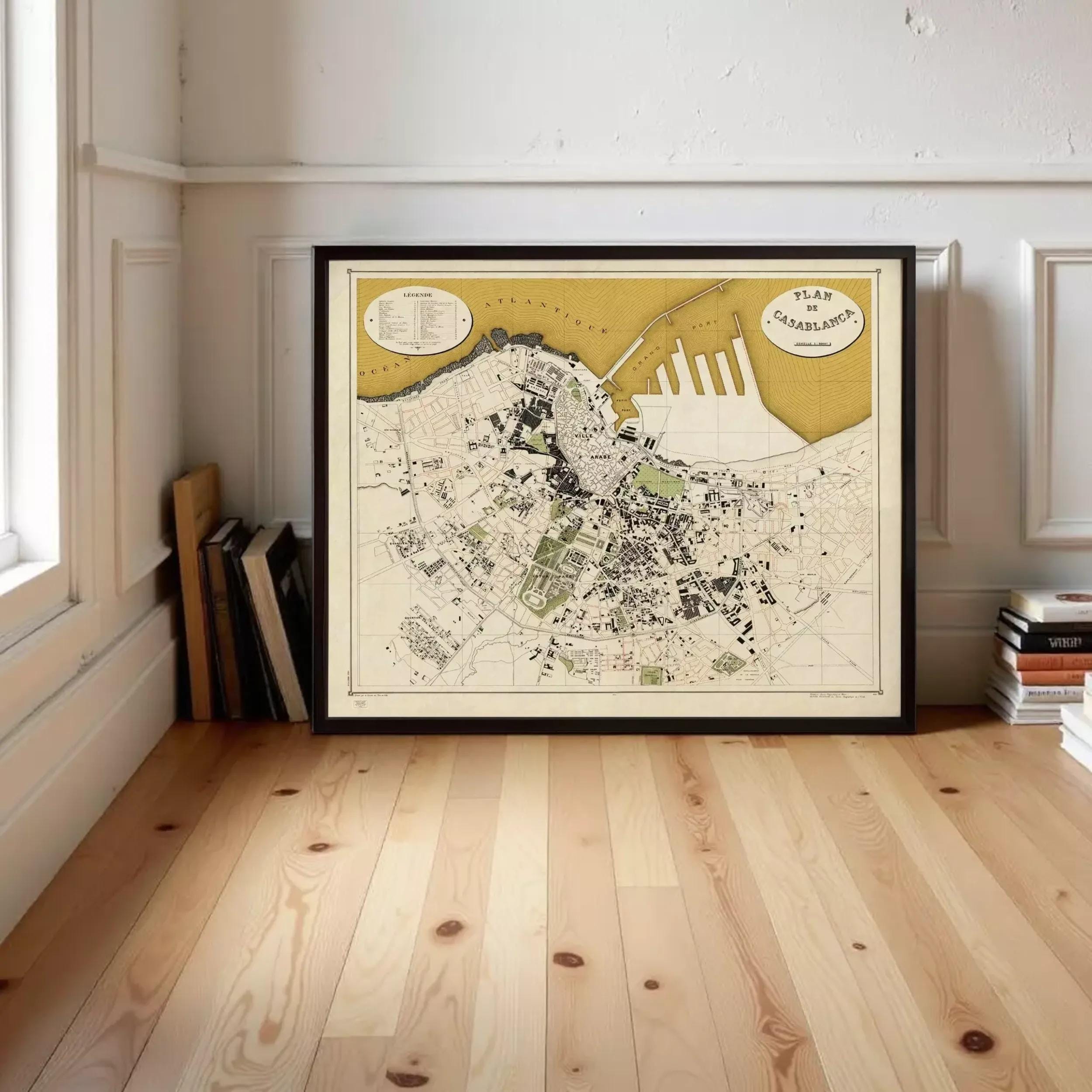a large framed map of a city, with a wooden floor and a bookshelf in the background.