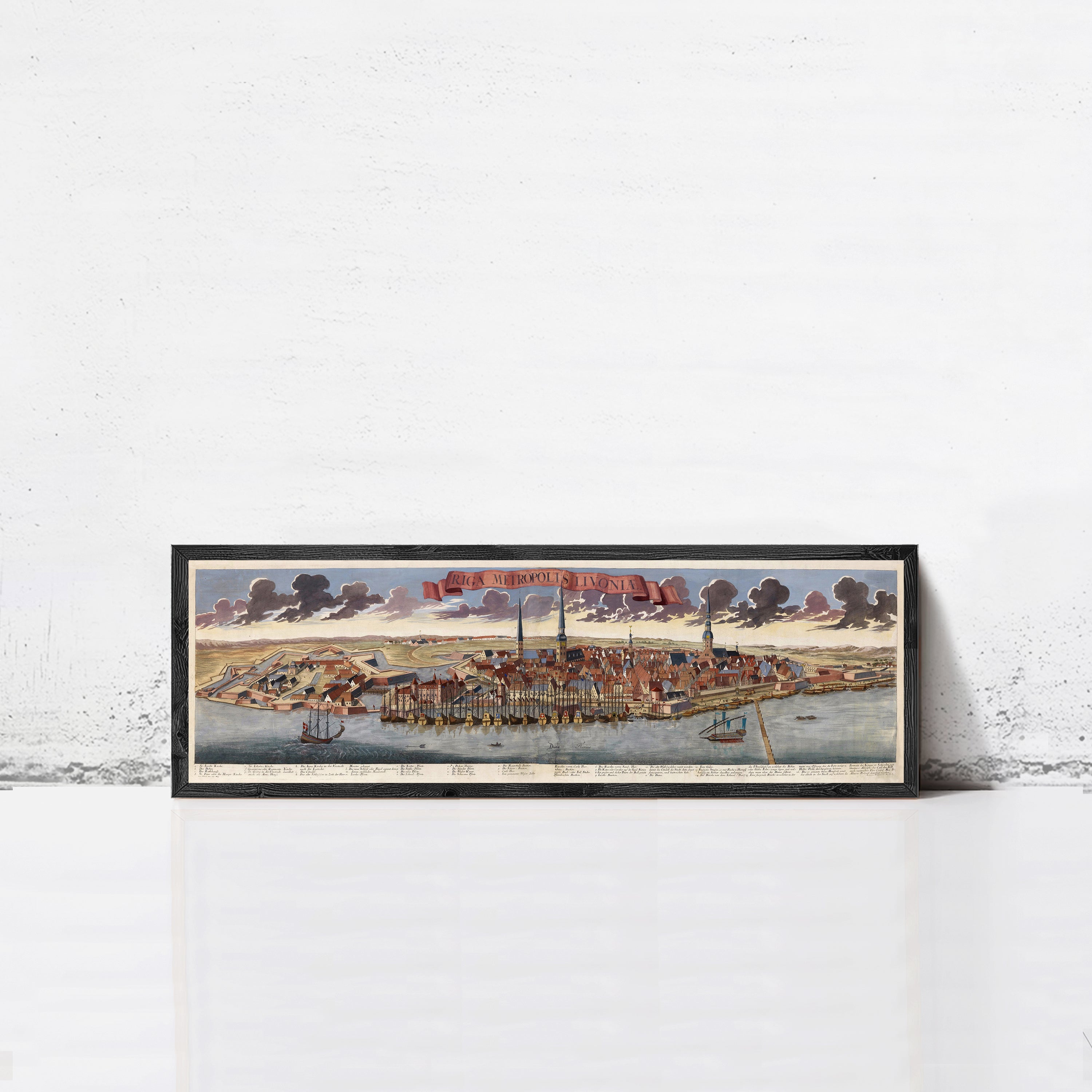 A framed painting depicting a cityscape with boats and ships in the water, set against a cloudy sky.