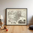 a large framed map of a city, with various landmarks and streets depicted. The map is placed on a wooden floor, and there are some books and a teddy bear nearby.