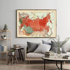 a large framed map of the world hanging on a wall in a living room setting.