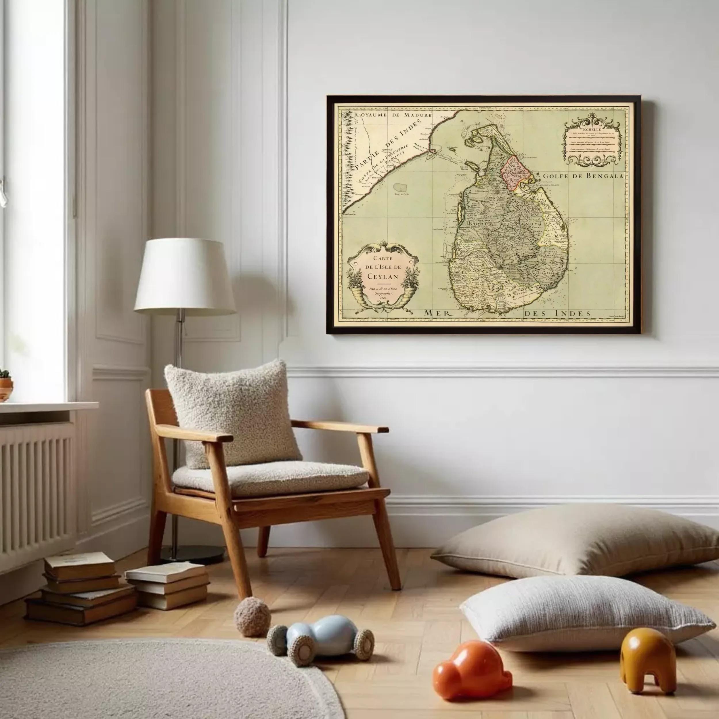 a cozy living room with a large framed map of Sri Lanka hanging on the wall. The room has a wooden chair, a lamp, and a stack of books on the floor. There are also some toys scattered around the room, adding a playful touch to the space.