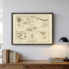 a framed map of the Lascaux Caves, a famous cave system in France, hanging on a wall above a wooden desk with a lamp and a stack of books.