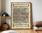 The image is a framed antique map of a city, likely from the Middle Ages, with intricate details and a vintage appearance.