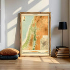 a large framed map of the Middle East, with a wooden frame and a black lamp on a shelf next to it.