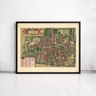 The image is a framed vintage map of a city, likely from the 16th century, displayed on a white wall.
