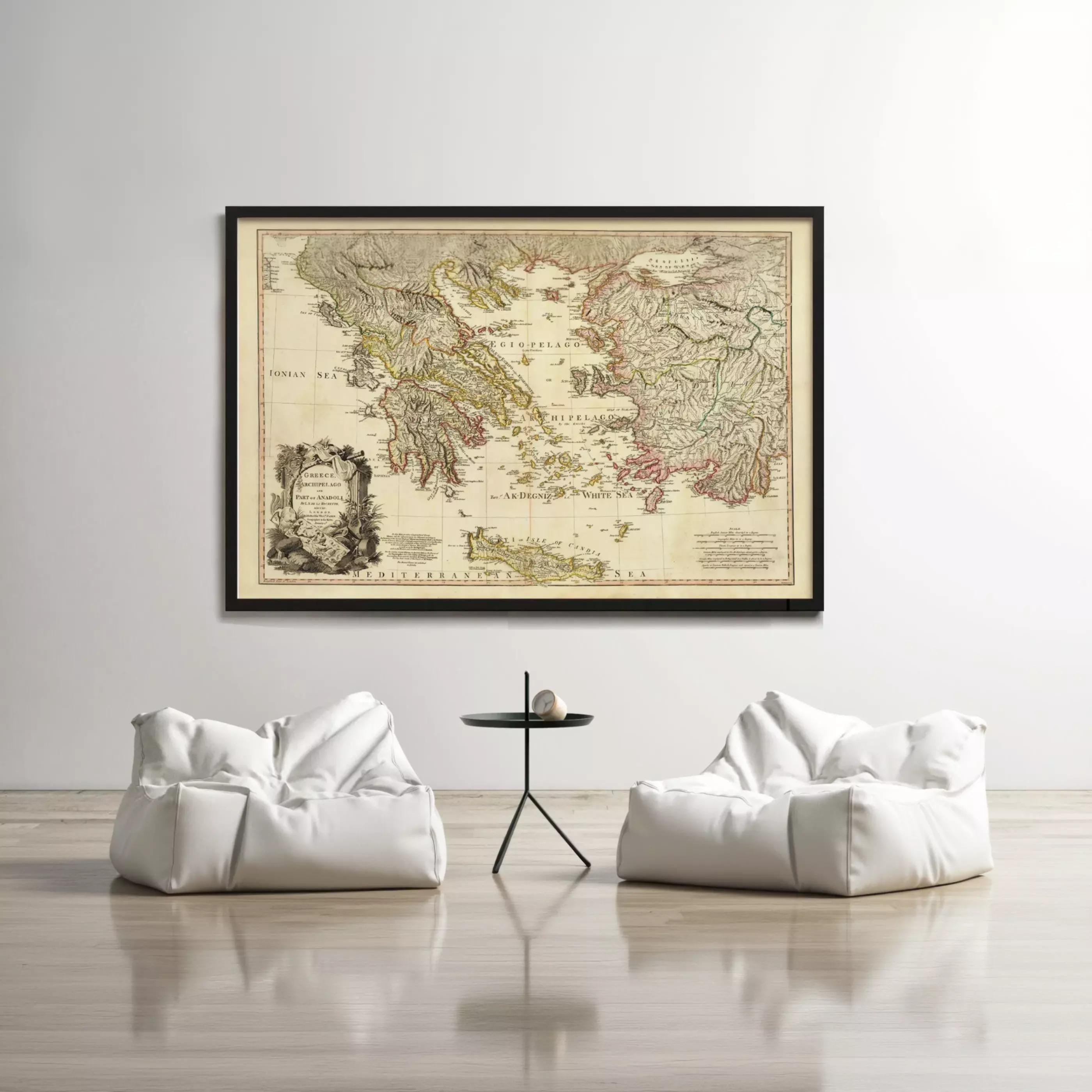 a large framed map of the world hanging on a white wall, with two white bean bag chairs positioned in front of it.