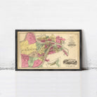 The image is a framed vintage map of a city, likely from the early 20th century, with various colored sections representing different neighborhoods or districts.