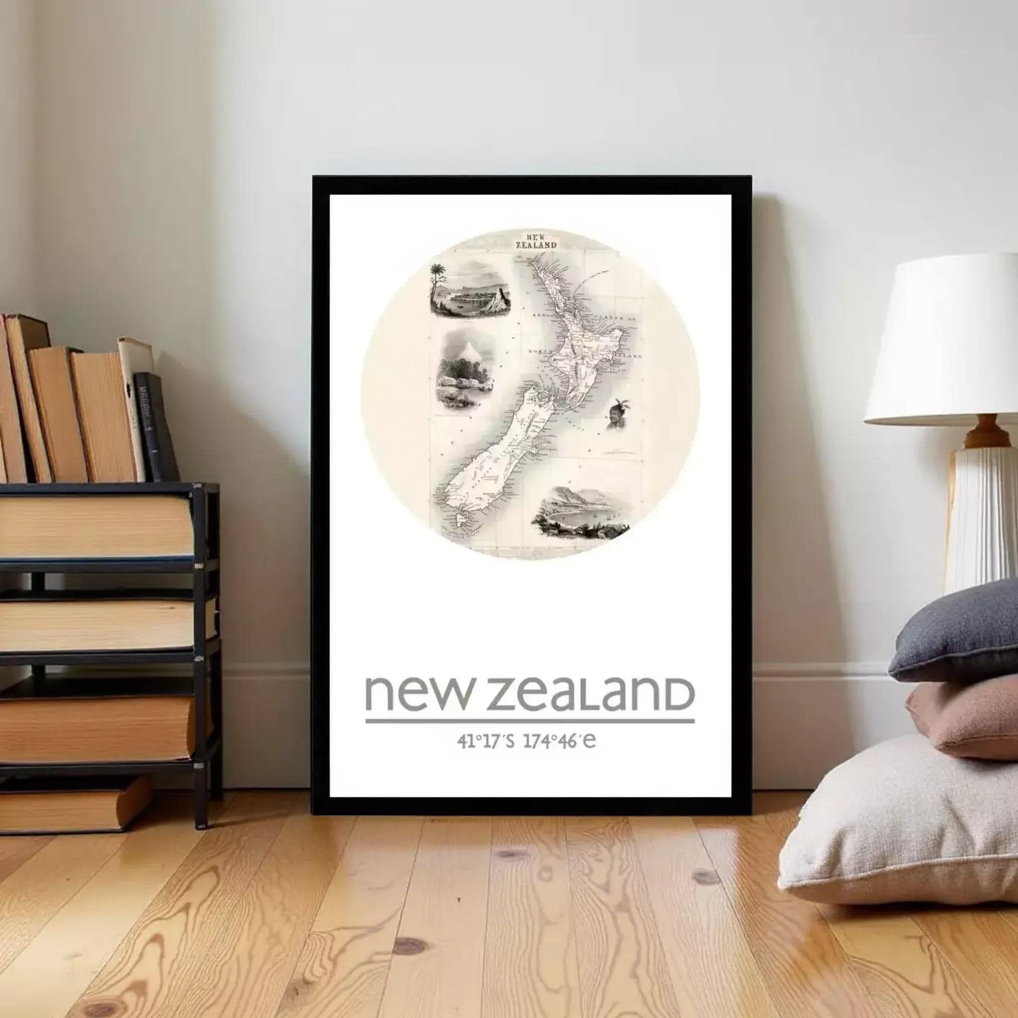 A framed poster of a map of New Zealand is displayed on a wall in a room with a bookshelf and a lamp.