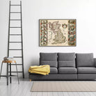 a gray sofa with a yellow blanket draped over it, and a framed map of the United Kingdom hanging on the wall above the sofa.