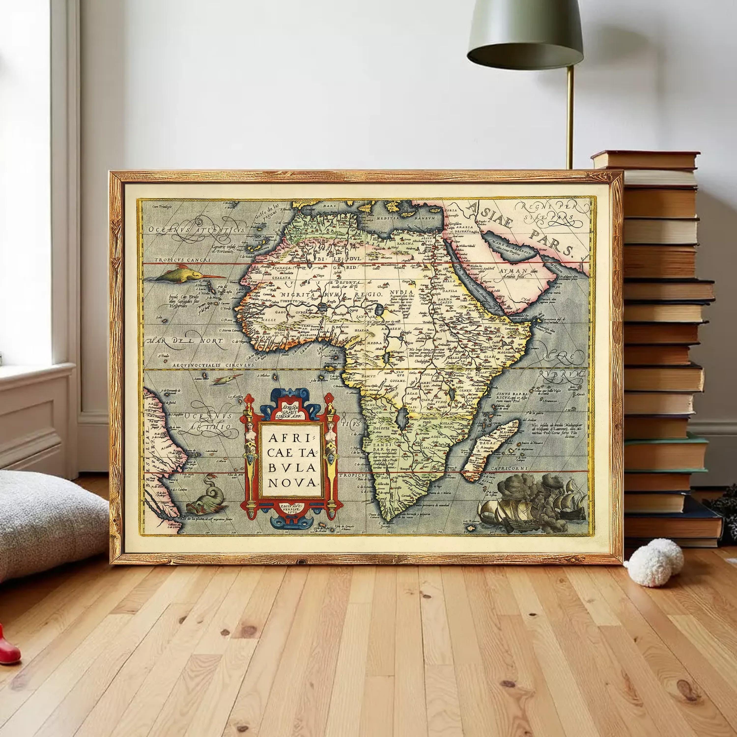 a large framed map of Africa, with various countries and regions clearly marked. The map is displayed on a wooden floor, with a stack of books and a lamp visible in the background.