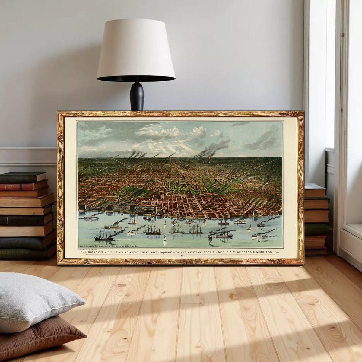 A framed painting depicting a cityscape with boats and ships in the water, situated in a room with a lamp and bookshelves.
