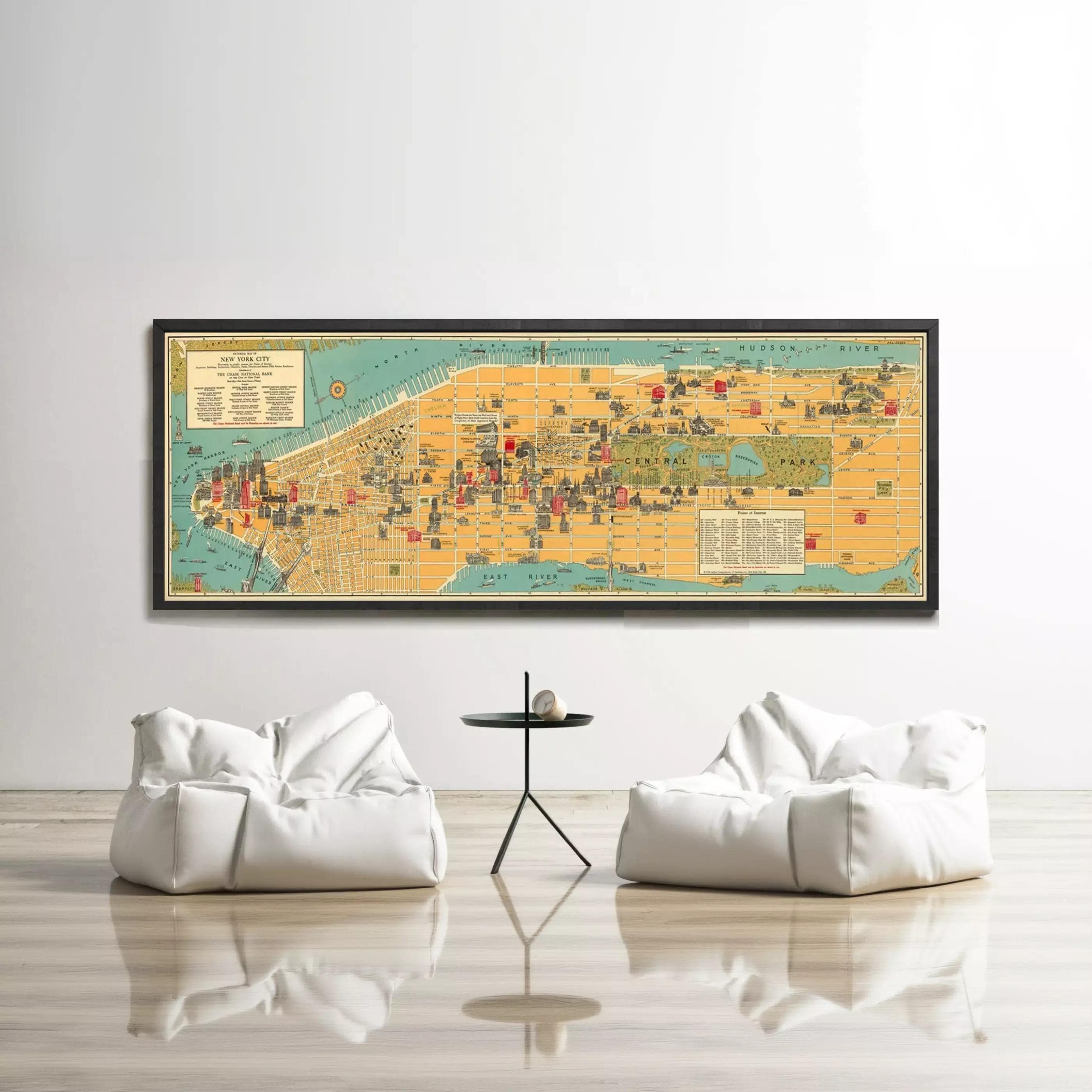 a large framed map of New York City hanging on a white wall, with two white bean bag chairs positioned in front of it.