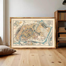 The image is a framed vintage map of a city, depicting various landmarks and streets in a detailed and colorful manner.