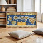 A framed map of the Hawaiian Islands is displayed on a wooden floor in a room with bookshelves and a lamp.