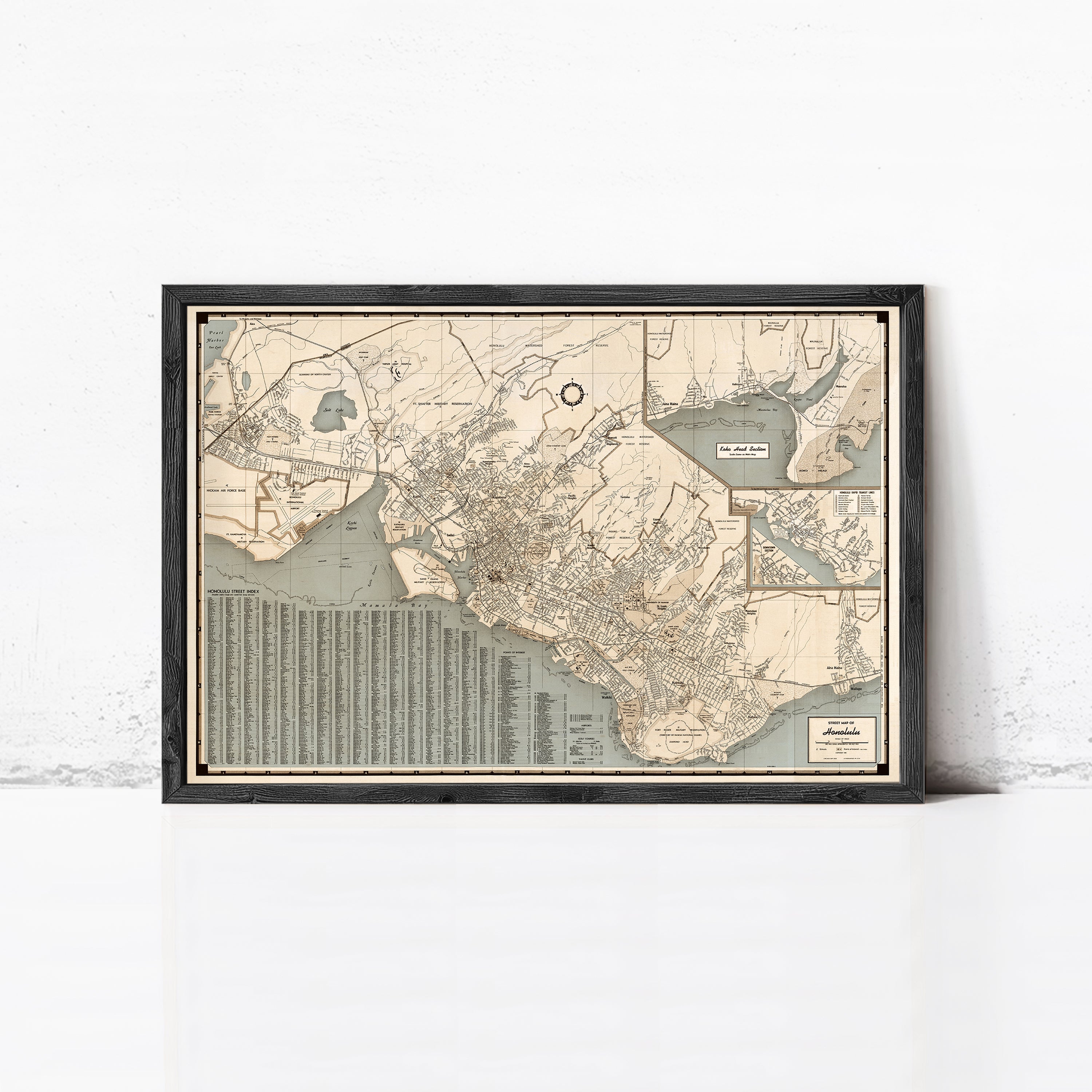 The image is a framed vintage map of a city, depicting various streets, landmarks, and bodies of water.