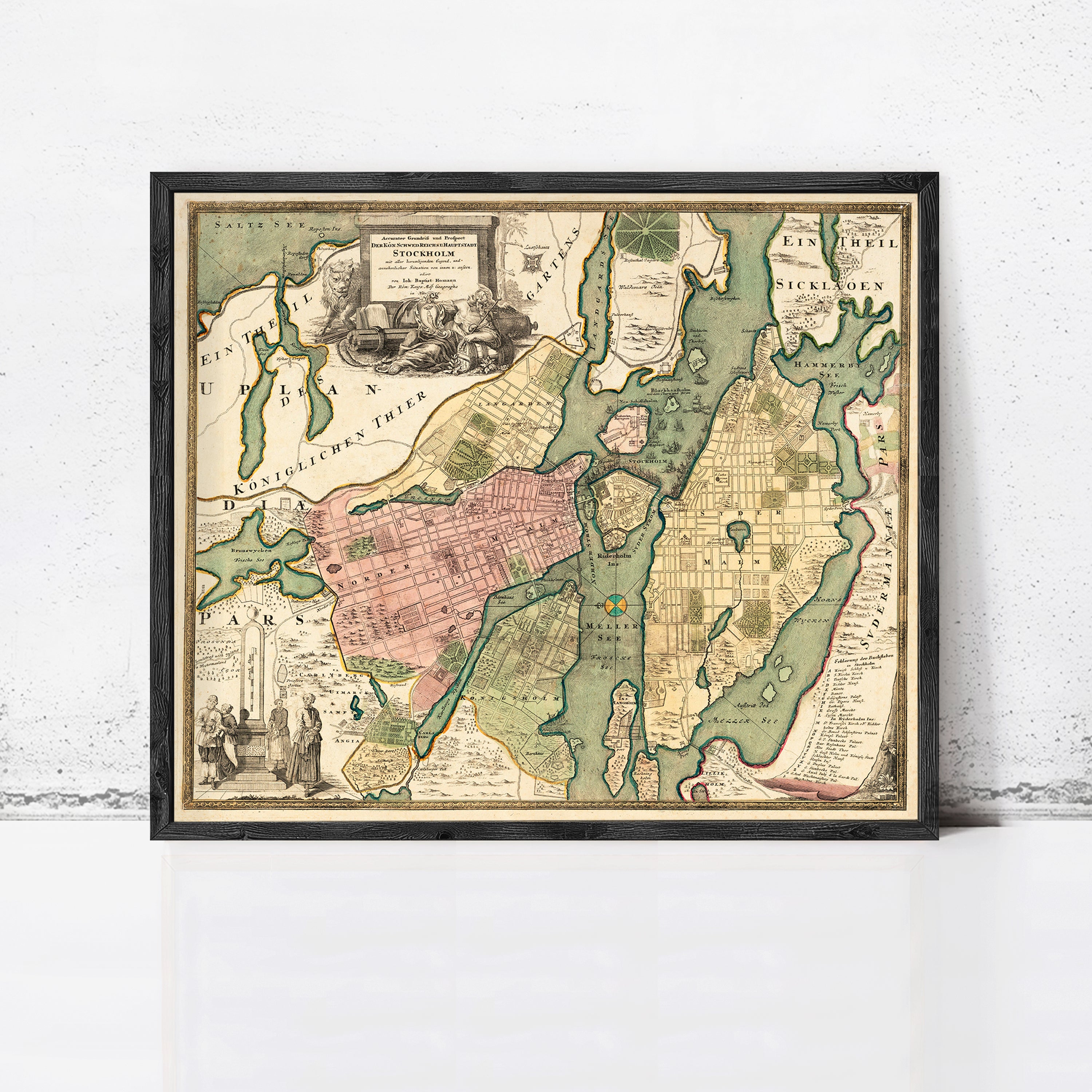 The image is a framed antique map of a city, likely from the 18th century, with detailed cartography and illustrations.