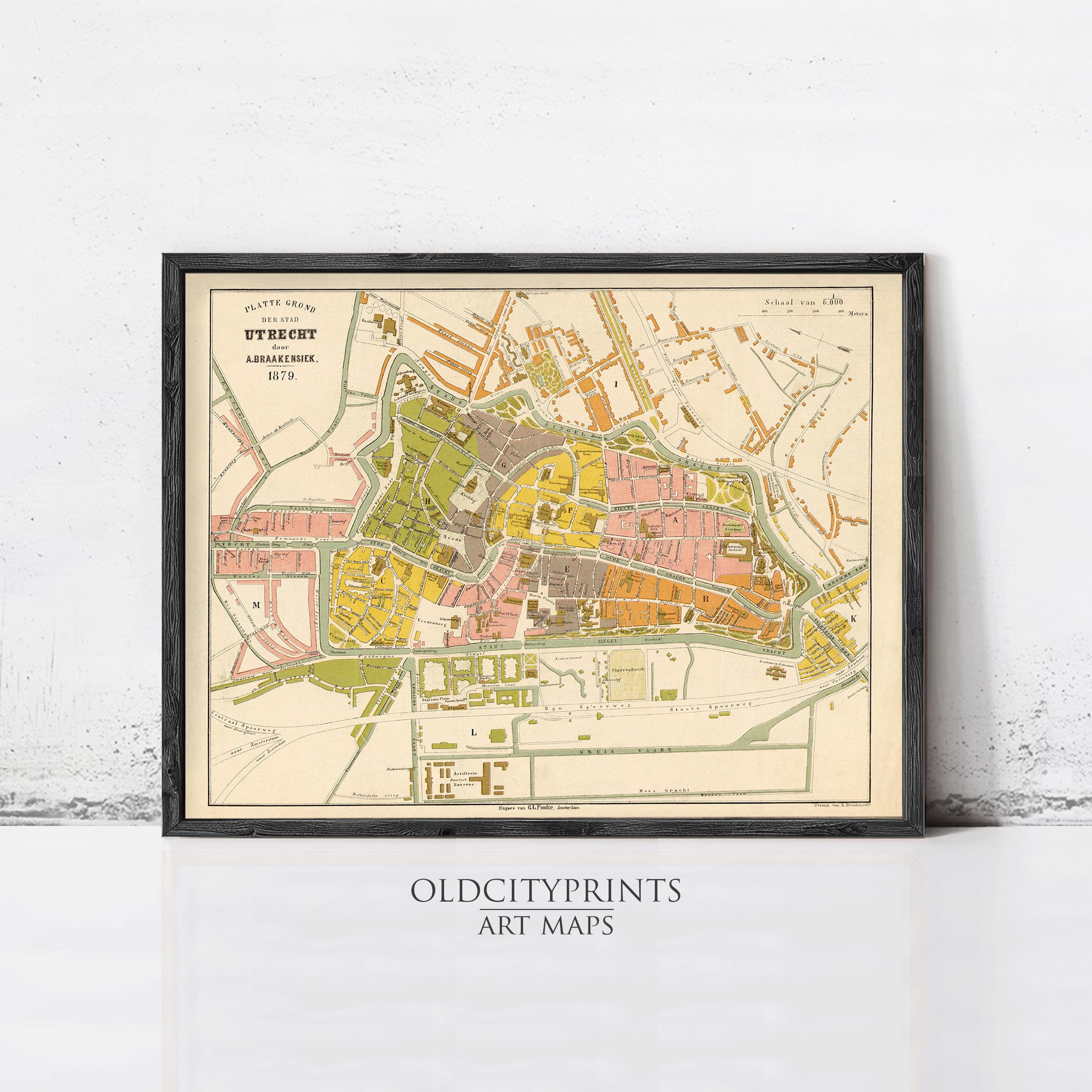 The image is a framed vintage map of a city, likely from the 19th century, with various colored areas representing different neighborhoods or districts.