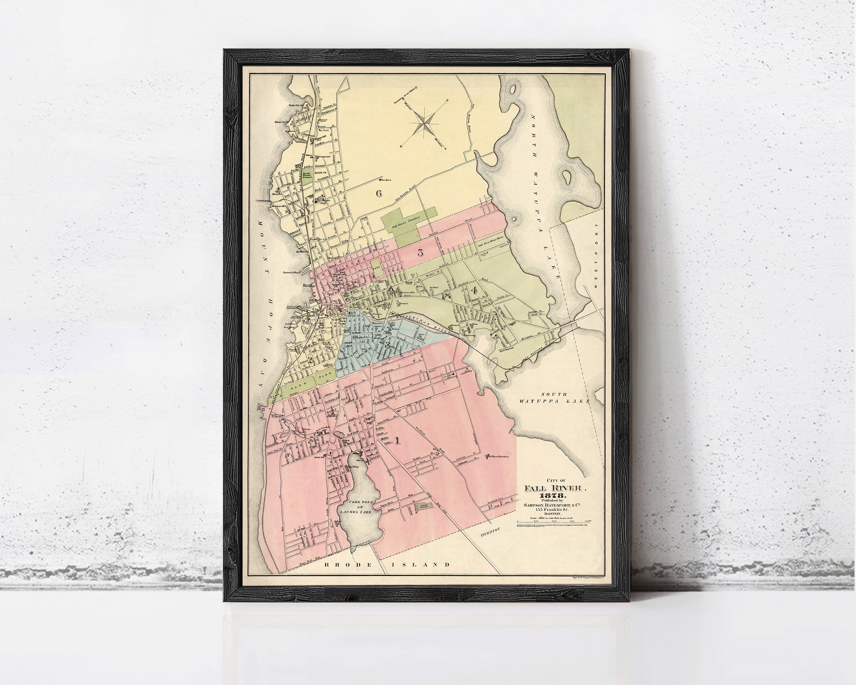 The image is a framed vintage map of a city, likely from the late 19th century, depicting the layout and boundaries of the city.
