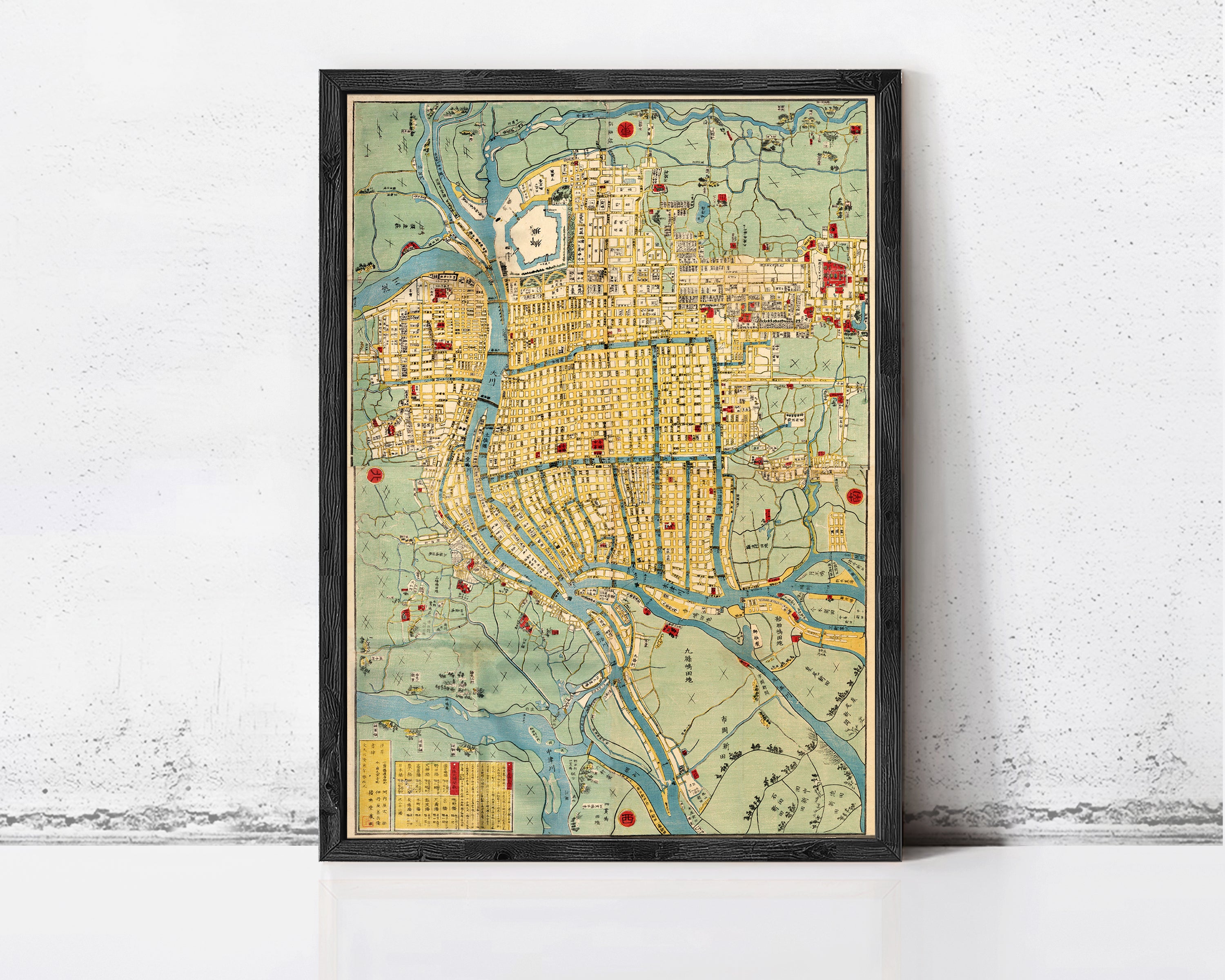 The image is a framed map of a city, likely from the 19th century, with various landmarks and streets depicted in a stylized manner.