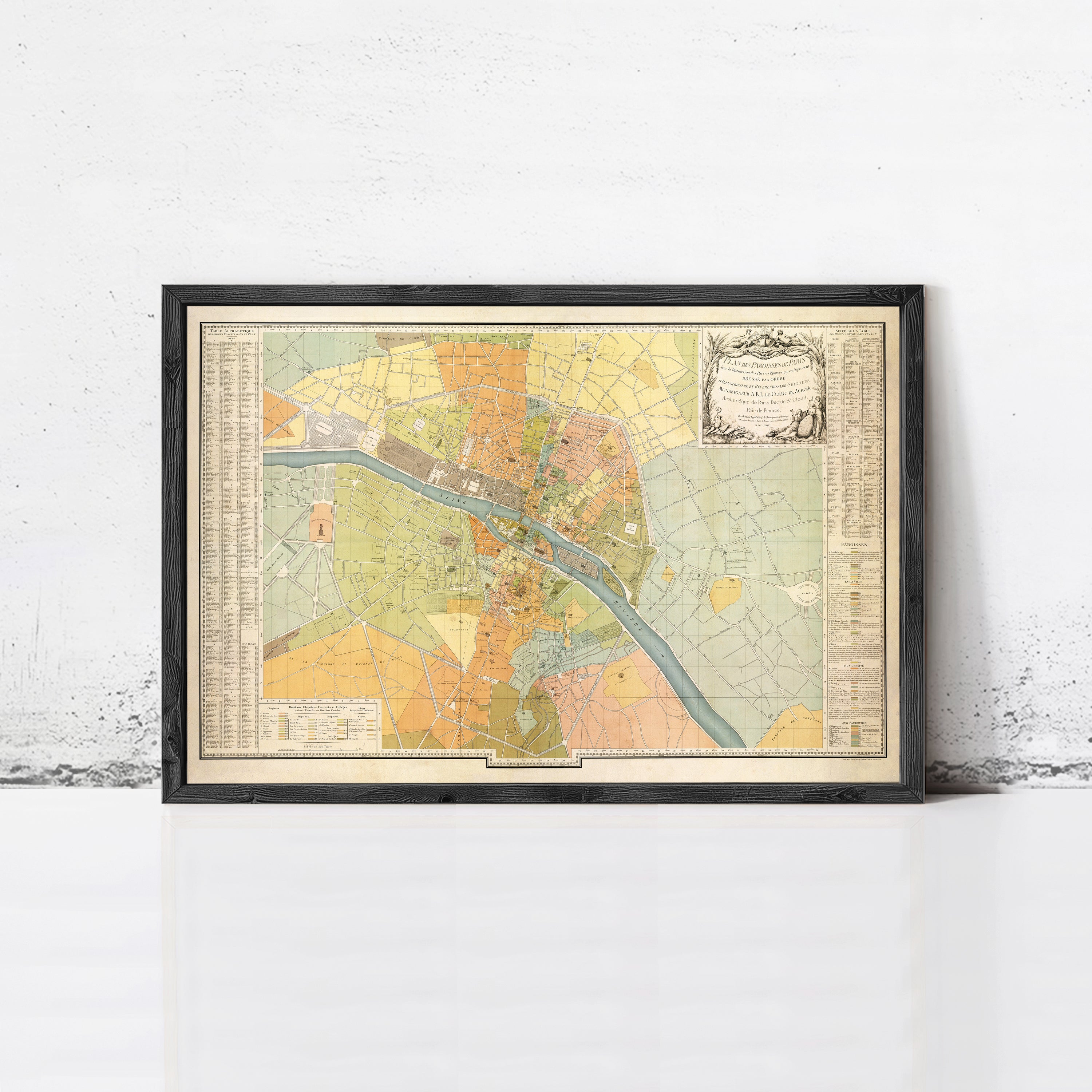 The image is a framed vintage map of a city, likely Paris, with various colored sections representing different areas within the city.