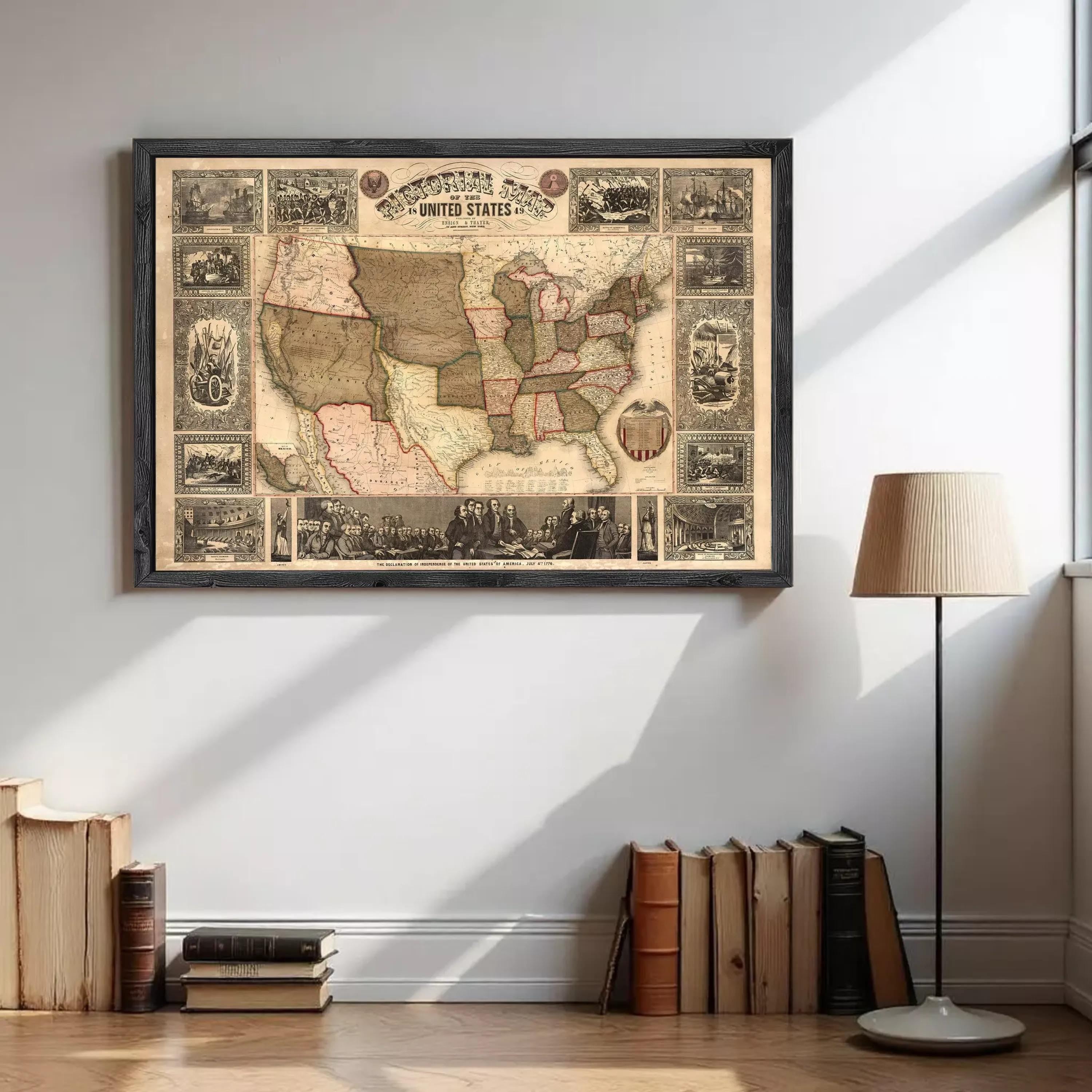 a framed map of the United States hanging on a wall, with a collection of books and a lamp placed nearby.