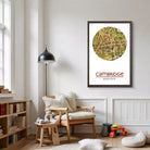 a cozy living room with a wooden chair, a lamp, and a bookshelf filled with books. A framed map of Cambridge is displayed on the wall, and a teddy bear is sitting on the chair.