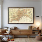a large framed map of Paris hanging on a wall, with a wooden cabinet below it and a cozy reading nook with a lamp and books nearby.