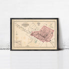 The image is a framed vintage map of a city, depicting a detailed layout of streets, buildings, and other urban features.
