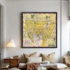The image is a framed vintage map of a city, likely from the early 20th century, depicting a detailed layout of streets, landmarks, and other geographic features.