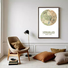 a cozy living room with a beige armchair, a wooden side table with a lamp, and a framed map of Versailles hanging on the wall.