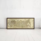 A framed antique map of the world is displayed against a white wall.