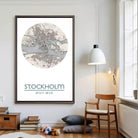 a large framed poster of a map of Stockholm, Sweden, hanging on a wall in a room with a wooden chair and a bookshelf.