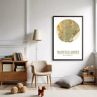 a cozy living room with a large framed map of Buenos Aires hanging on the wall, a lamp, a chair, a bookshelf, and a stuffed animal on the floor.