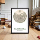The image is a framed print of a map of Amsterdam, with the city's name and location printed below the map.