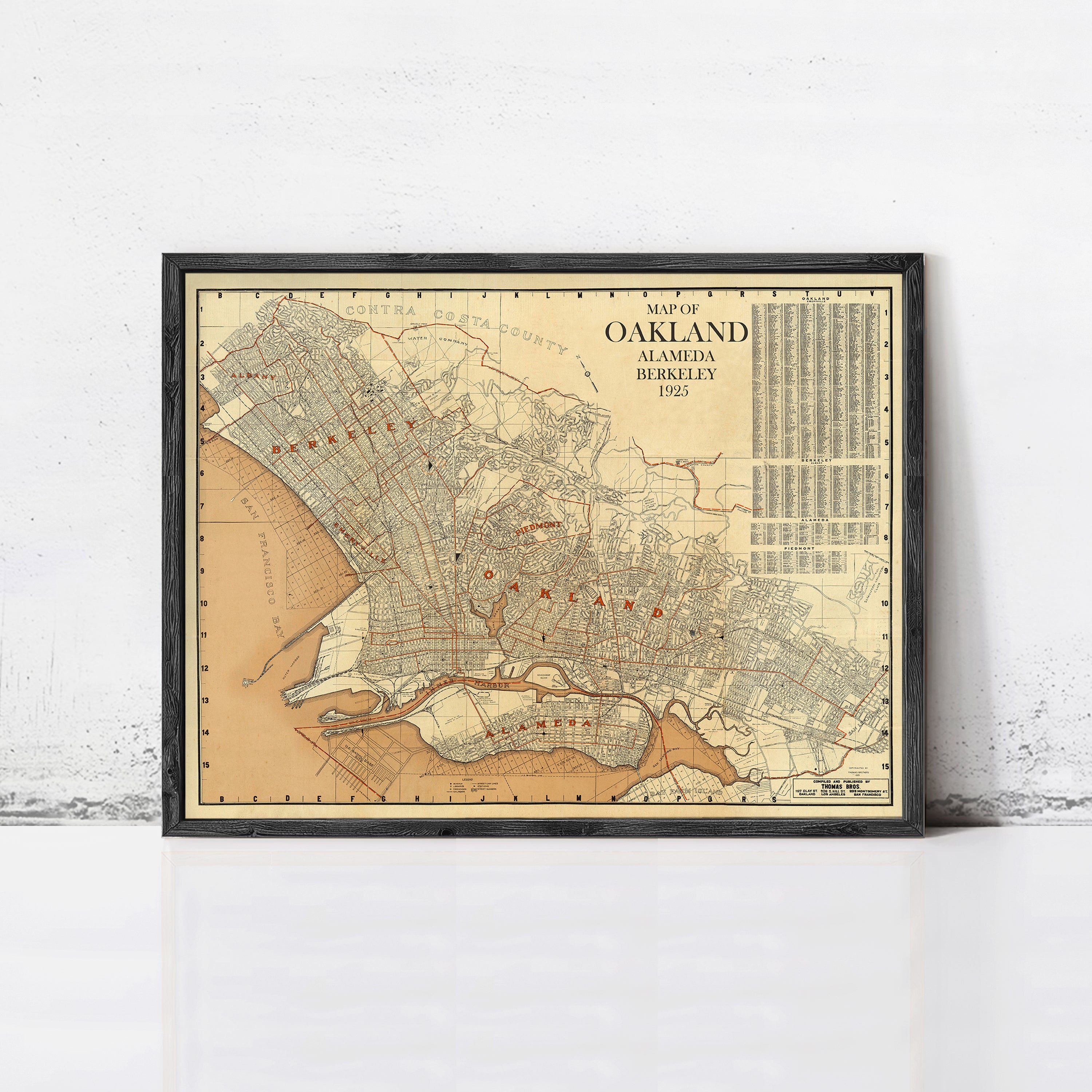 The image is a framed vintage map of Oakland, California, showing the city's streets and surrounding areas.