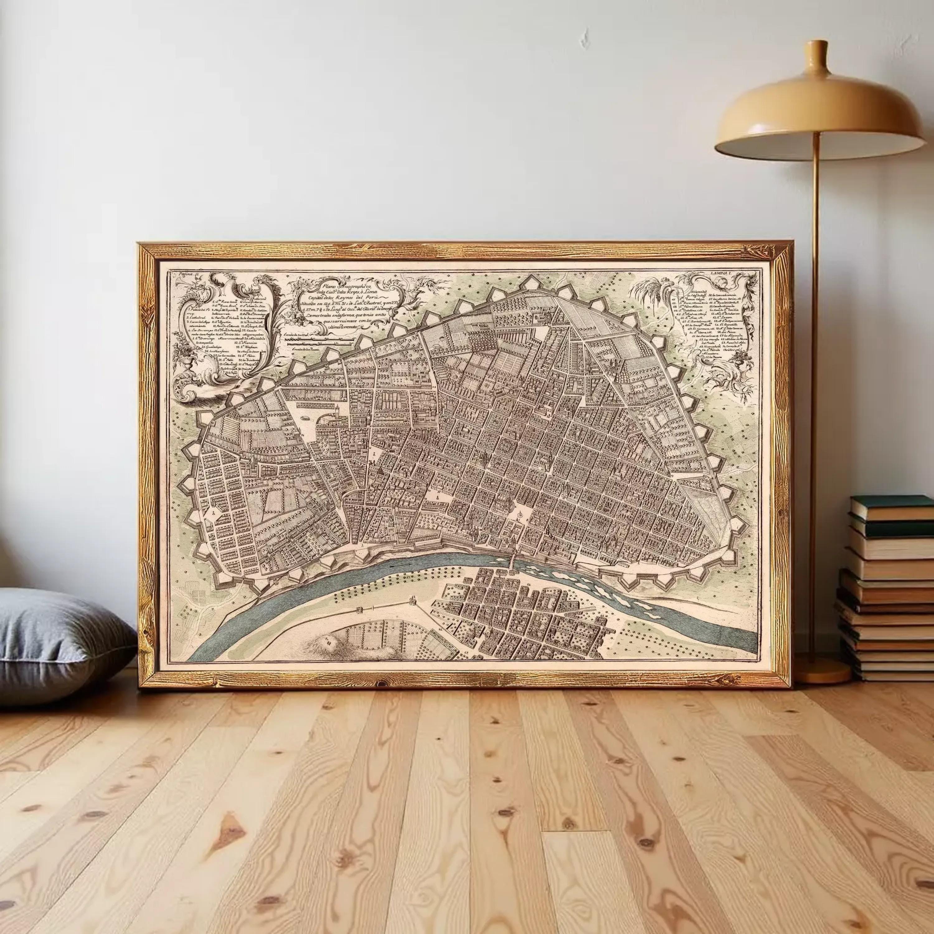 The image is a framed antique map of a city, likely from the 17th century, displayed on a white wall.