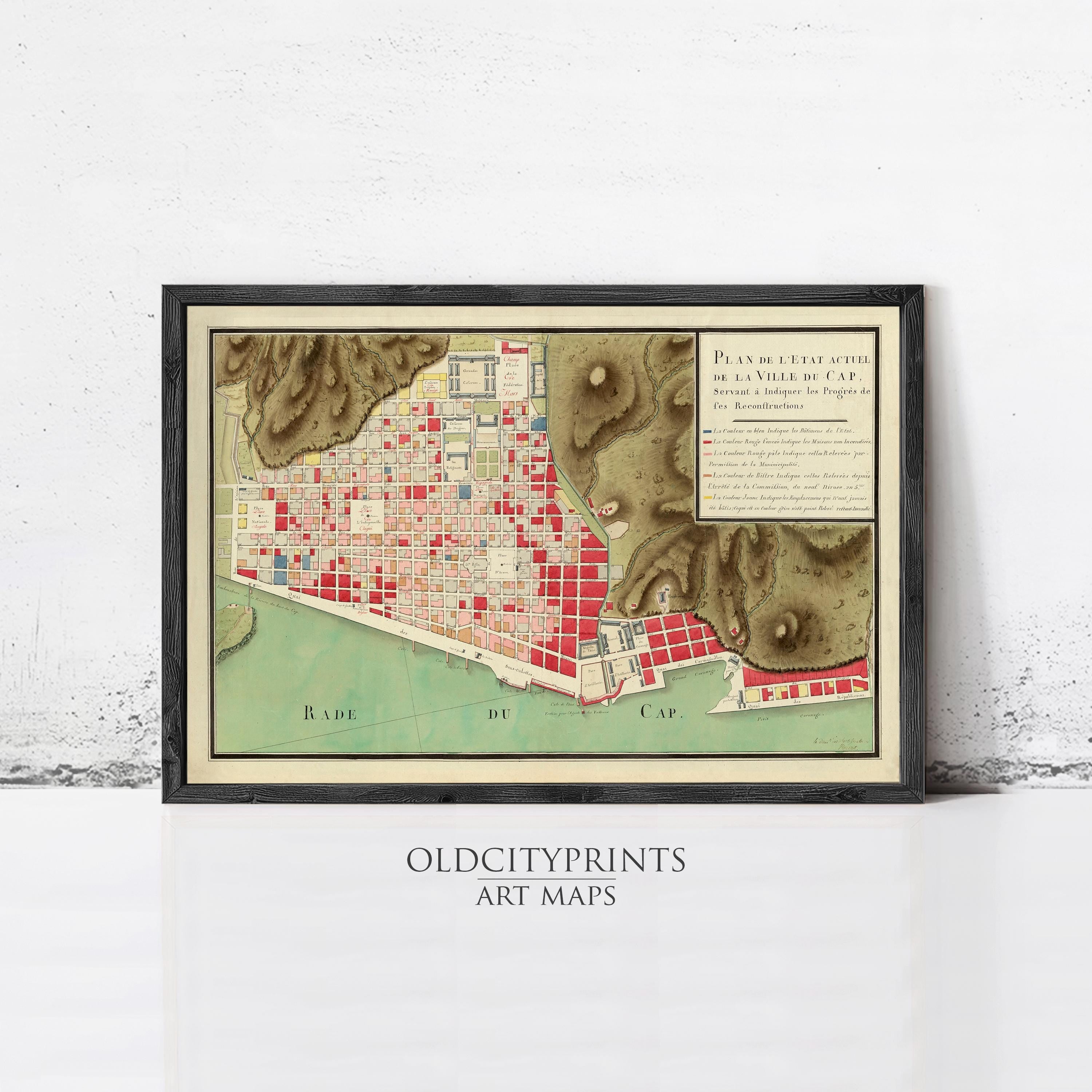 The image is a framed art print depicting a map of a city, with various buildings and landmarks represented in different colors.
