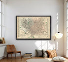 The image is a framed vintage map of a city, likely from the early 20th century, displayed on a white wall.