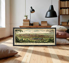 A framed illustration of a cityscape depicting a large, densely populated urban area with a mix of buildings, roads, and natural elements such as trees and grass.