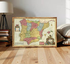 The image is a framed vintage map of Spain, featuring colorful regions and labels.