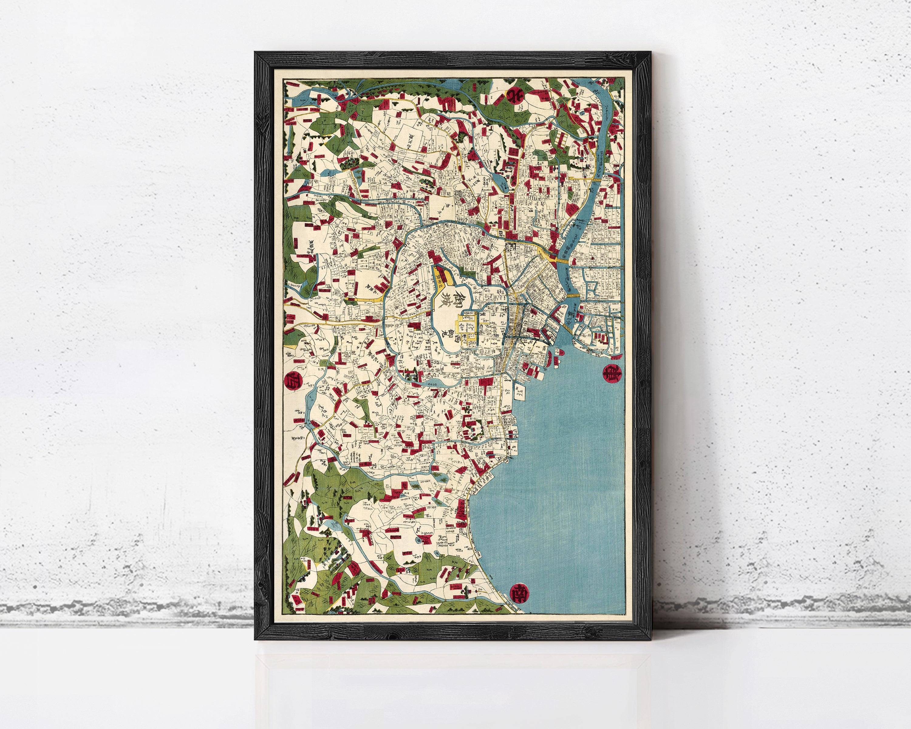 The image is a framed vintage map of a city, featuring a detailed and colorful depiction of the urban landscape.